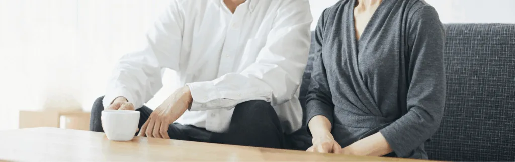 今後のライフプランについて相談に来たご夫婦の写真。首から下の写真で、夫婦はソファに座っていて、リラックスした様子。